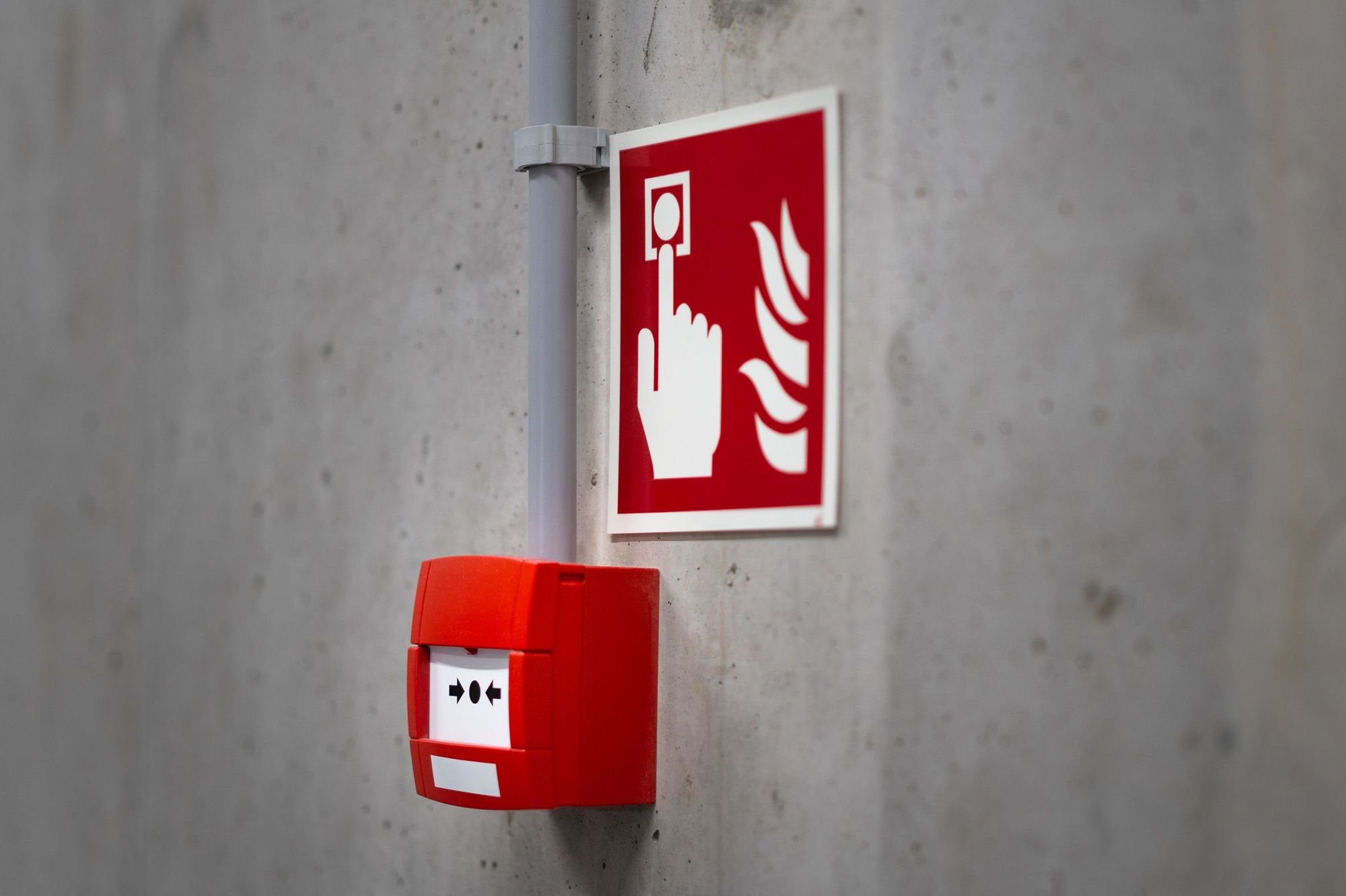 Handfeuermelder einer Brandmeldeanlage mit Brandschutzzeichen